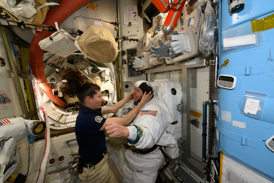 ISSのエアロックで宇宙服のフィットチェックをするBarratt氏（右）を助けるDyson氏（出典：NASA）