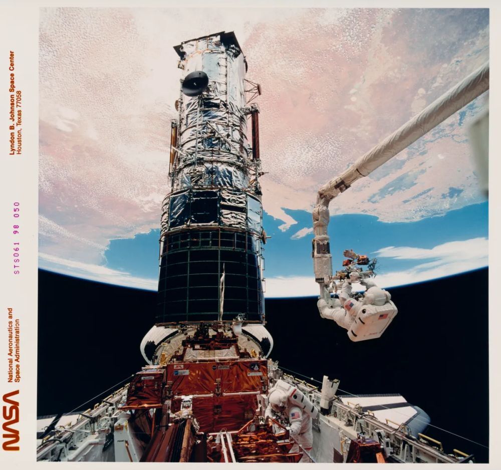 NASAの宇宙飛行士Story Musgrave氏が、リモートマニピュレーターシステムに固定されている。磁力計に保護カバーを取り付けるためにハッブル宇宙望遠鏡の上部に持ち上げられる準備をしているところだ（提供：Getty Images）