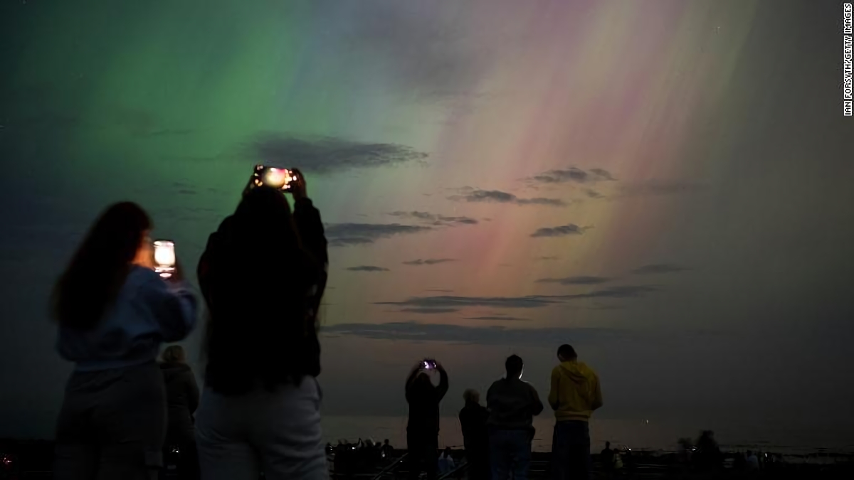 北極光を写真に収める人々＝１０日、英イングランド・ウィットリーベイ/Ian Forsyth/Getty Images